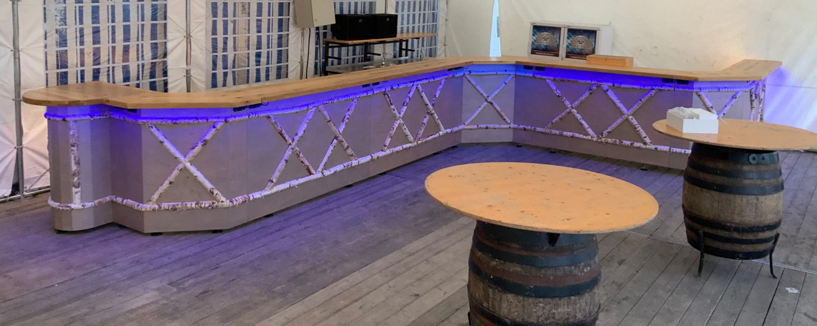Mobile Holzbar mit Birkenstämmen und blauer Beleuchtung