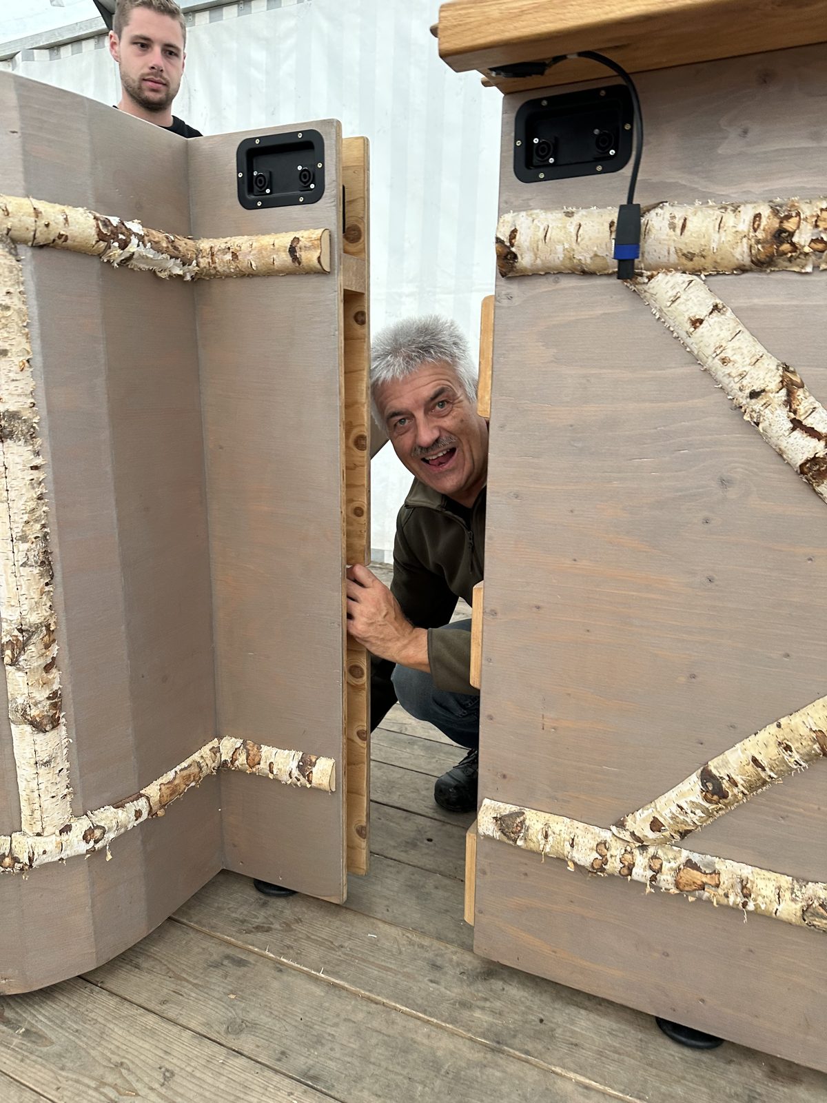 Sepp schaut beim Aufbau durch die Barelemente
