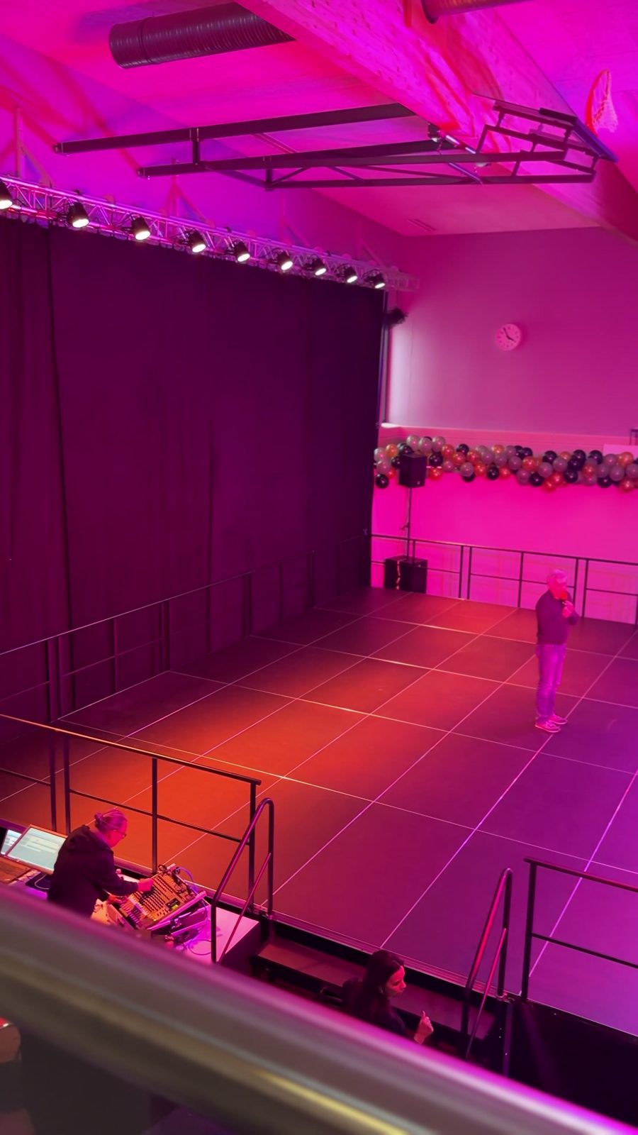 Bühne in einer Halle, in Rot und Pink beleuchtet