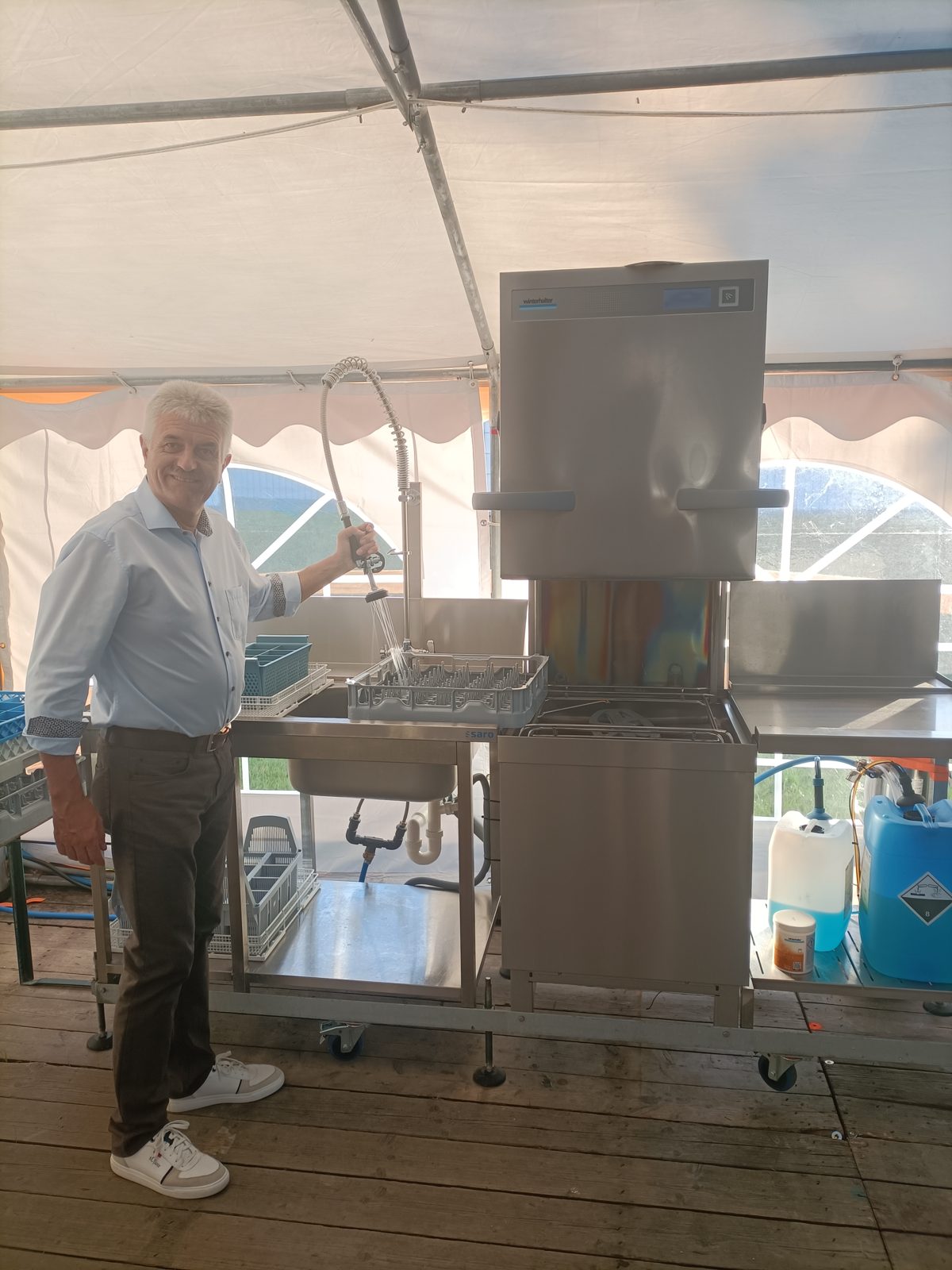 Sepp mit der Vorspülbrause an der Haubenspülmaschine im Festzelt