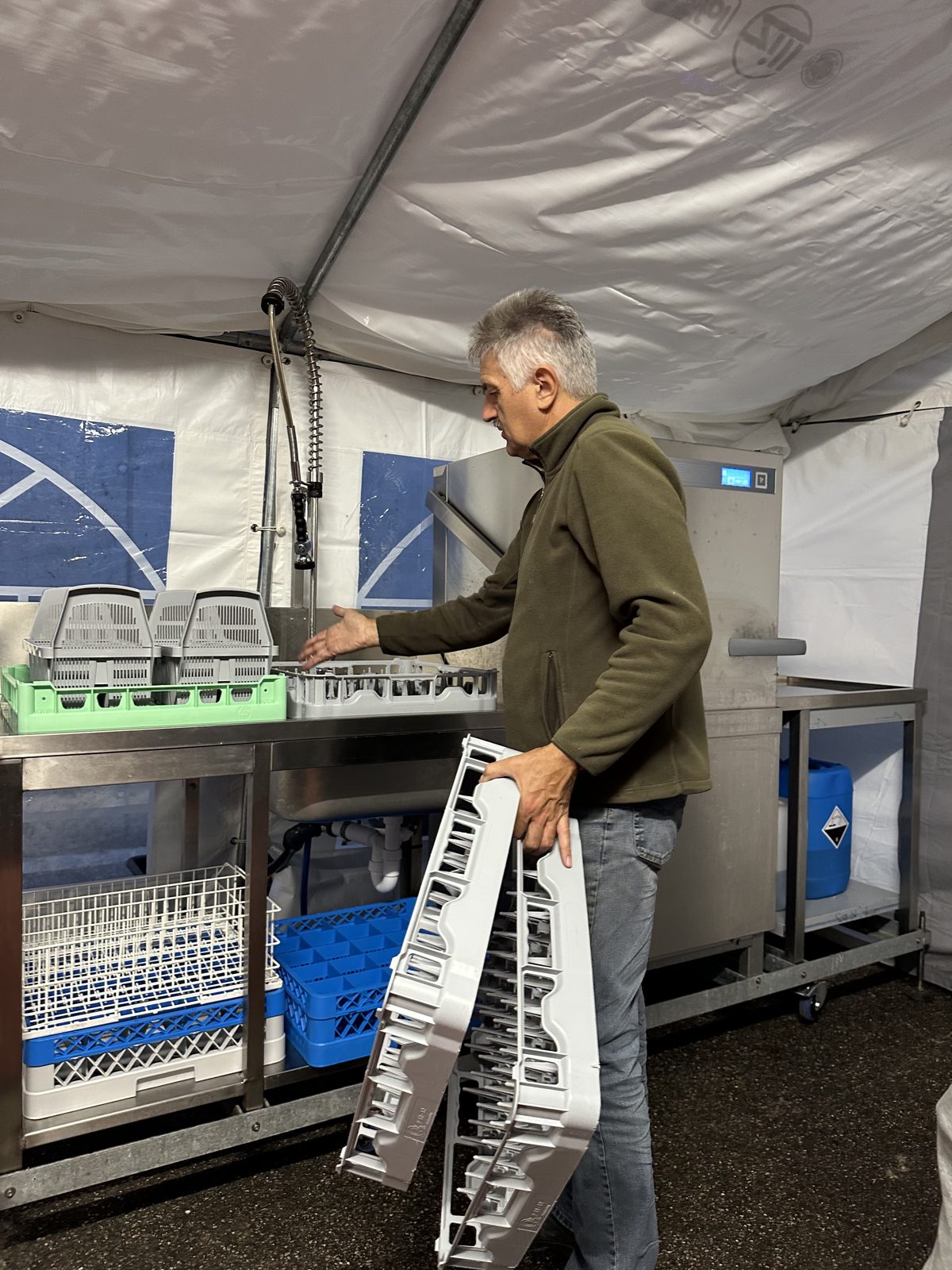 Spültisch im Festzelt, darunter Kisten und Körbe